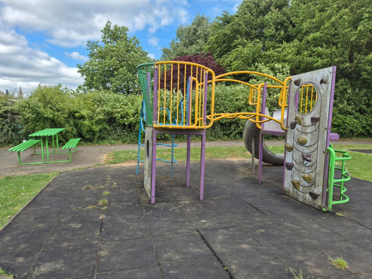 Filthy climbing frame with worn out ground surface.